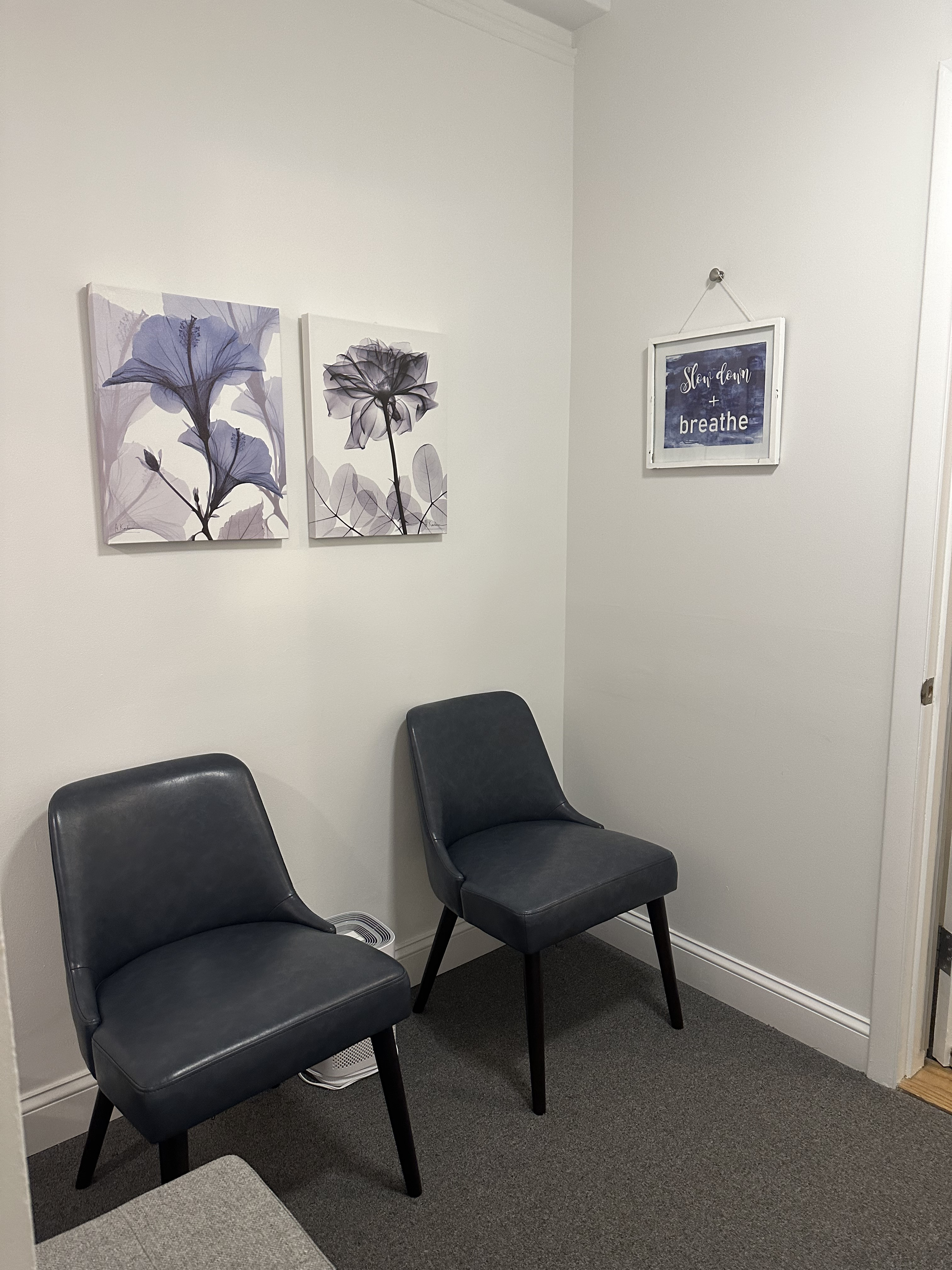 Waiting room furnished with armchair and art on walls